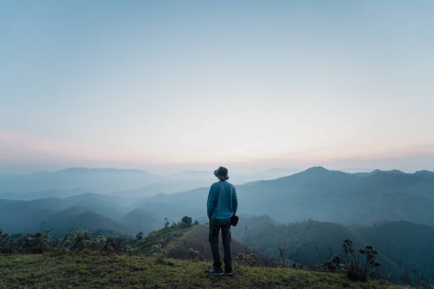 istock Rear View Of Man Standing On Mountain Against Sky 1419113612