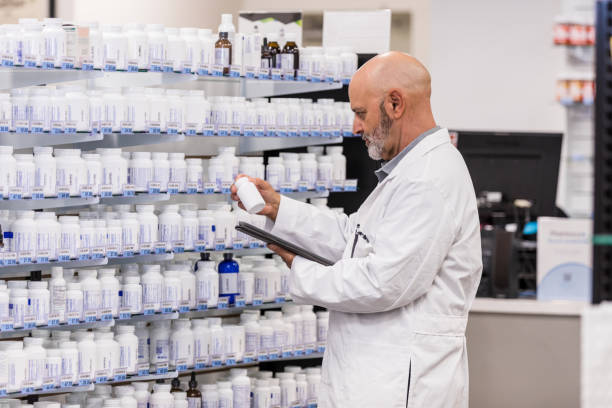 istock Pharmacist reads prescription bottle 1419113621