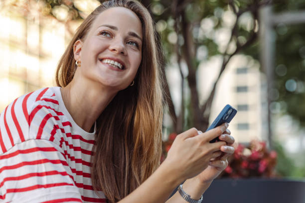 istock Beautiful young woman using smart phone and smiling 1419116516