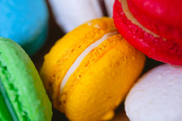 Macarons or Macaroons, sweet food. Biscuit made with almond flour. A stack of Macarons on a wooden board and a red napkin in the background. Food, Dessert, French, Sugar.