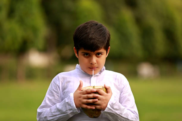 Child drinking coconut water outdoor in nature