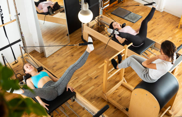 istock Young women practicing Pilates on reformer at gym 1419121728