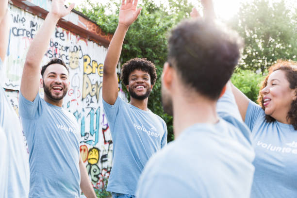 istock Diverse volunteer group raises hands and cheers in unity 1419122255