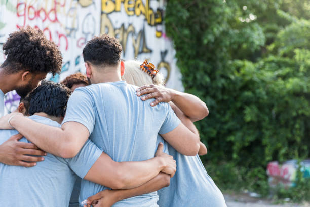 istock Unrecognizable group huddles with arms around each other 1419122275