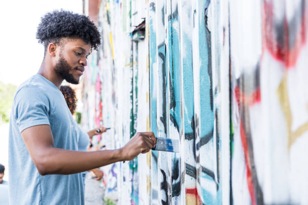 istock Low angle view male student painting over graffiti 1419122298