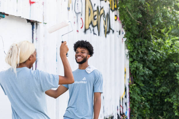 istock Siblings goof off while painting over graffiti 1419122355