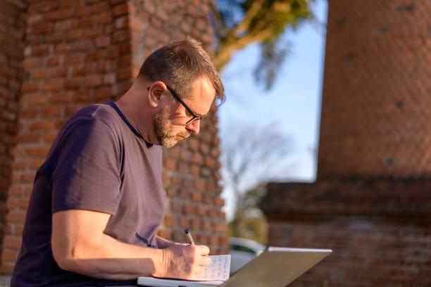 istock A handsome mature man studying in the park on a sunny day 1419122385