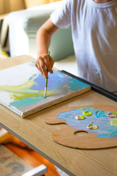 istock Child painting on canvas with acrilic paint. 1419123683