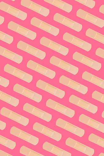 Adhesive bandages on pink background