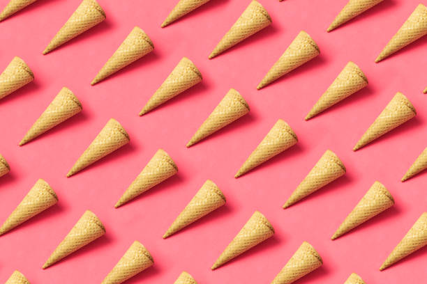 Conceptual still life with ice cream cones on pink background