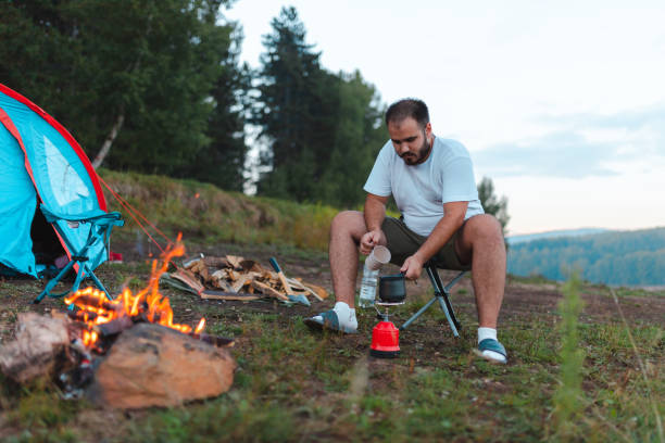 istock Young male hiker making coffee outdoors on a camping stove 1419130953