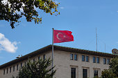 View of Turkish flag waving in front of state owned radio's building by one of the main avenues called Halaskargazi in Sisli district of Istanbul.