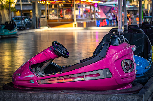 A woman and her young daughter enjoying a day out at the fair in Newcastle upon Tyne, North East England. They are on the bumper cars and the girl is screaming with her eyes closed while her mother looks excited.