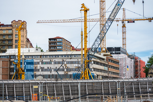Gothenburg, Sweden - June 06 2022: Multiple cranes and buildings under construction or being renovated.