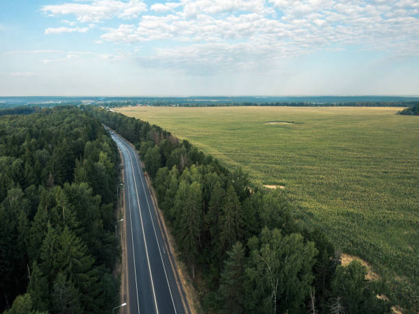 aerial view of empty multiple lane highway and agriculture field in the morning - multiple lane highway highway car field imagens e fotografias de stock