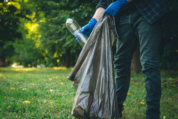 istock A man cleans up the forest, throws a bottle into a trash bag, close-up. 1419136666