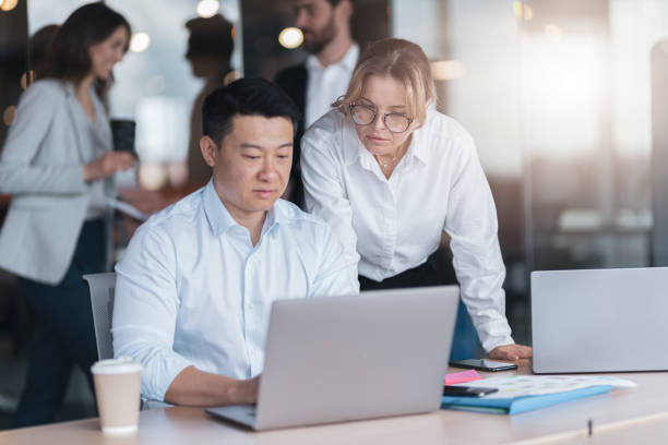 istock Two business people focused while working on a laptop together at boardroom table in office 1419137655