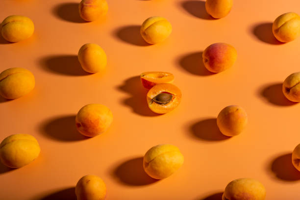 istock fresh apricots in a cut with a stone on an orange background pattern 1419137713