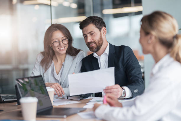 istock Smiling businessmen drink coffee and discussing documents with graphs and charts 1419138030