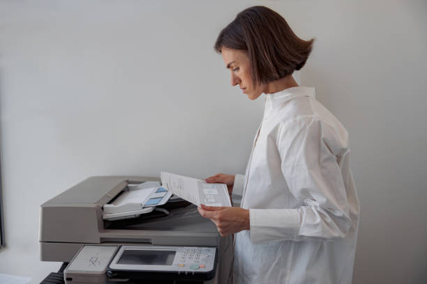 istock Focused woman worker scanning a document on photocopy machine In modern office 1419139746
