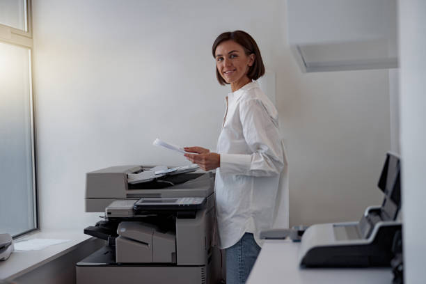 istock Smiling woman worker scanning a document on photocopy machine In modern office 1419139781
