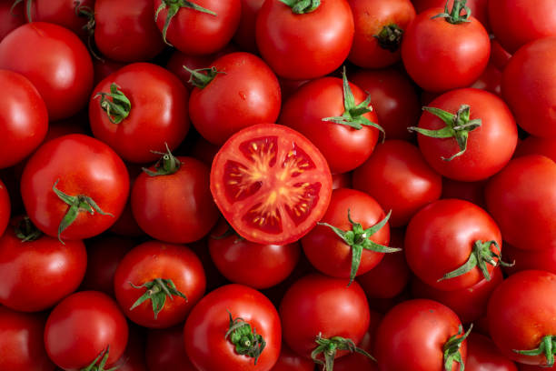 cut red tomato close-up in a box - tomaat stockfoto's en -beelden