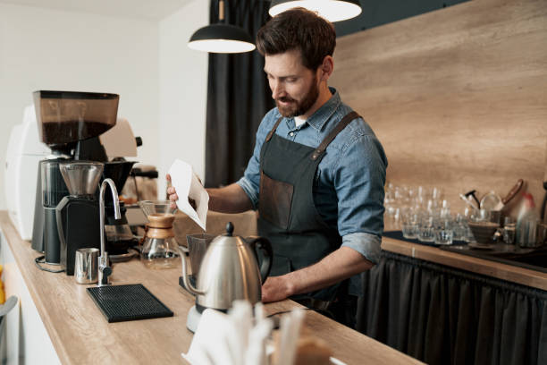 istock barista pours coffee beans into the coffee machine container for grinding 1419141666