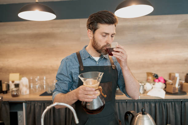 istock Barista tasting a freshly brewed filter coffee standing behind counter 1419142825