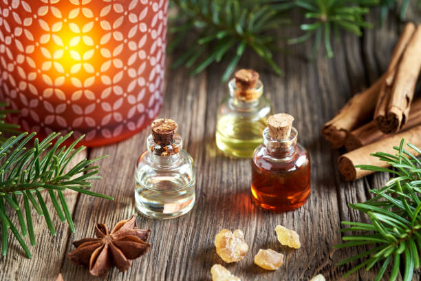 christmas selection of essential oils with frankincense, cinnamon and an aroma lamp - tree resin imagens e fotografias de stock