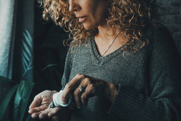 Close up of woman taking pills alone at home. Vitamins and diet medicine. Symptoms of influenza flu health. Female people take pharmacy pill on the hand. Headache or virus unhealthy day. Insomnia stock photo