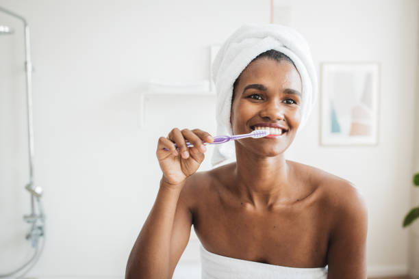 istock Smiling woman brushing healthy teeth in bathroom 1419147038