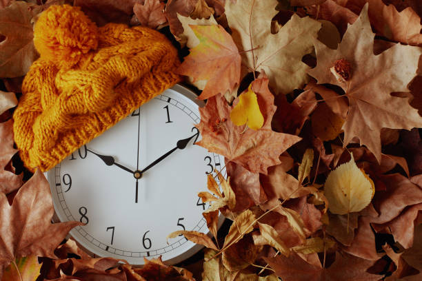 istock autumn background with clock, hat and leaves 1419150698