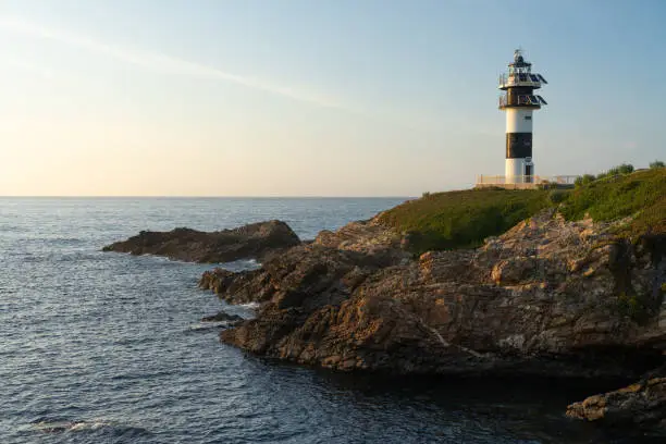 Photo of Pancha island lighthouse at sunset in Ribadeo coast, Lugo province, Galicia, Spain