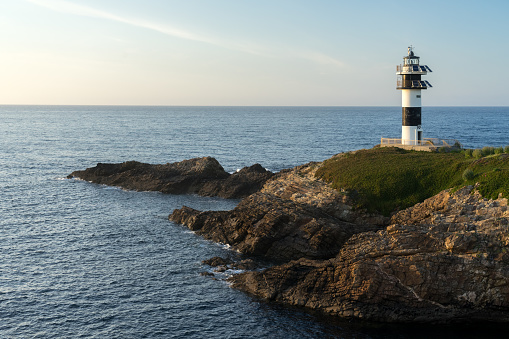 Pancha island lighthouse at sunset in Ribadeo coast, Lugo province, Galicia, Spain