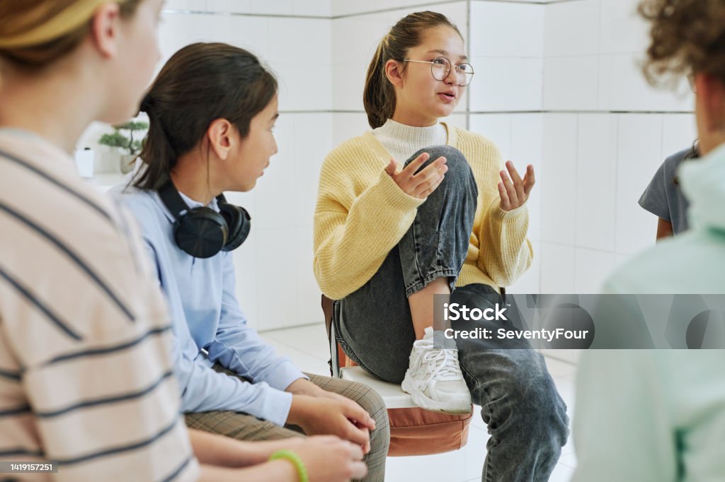Girl Sharing in Support Group Portrait of teenage girl sharing feelings in support group circle for children Teenager Stock Photo