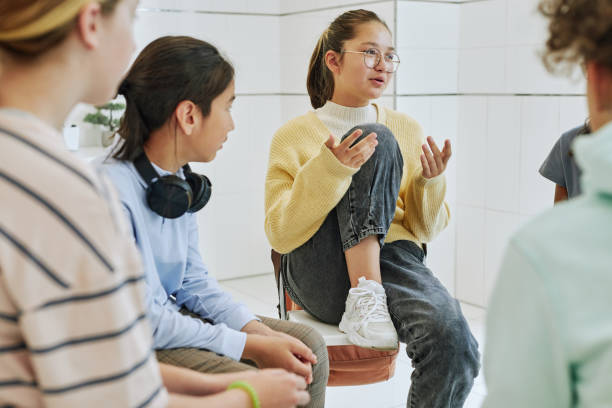Girl Sharing in Support Group Portrait of teenage girl sharing feelings in support group circle for children group therapy stock pictures, royalty-free photos & images