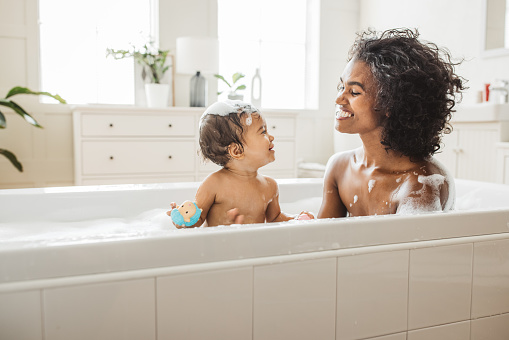 Mother and baby bathing at home. They are happy and enjoying in their routine.