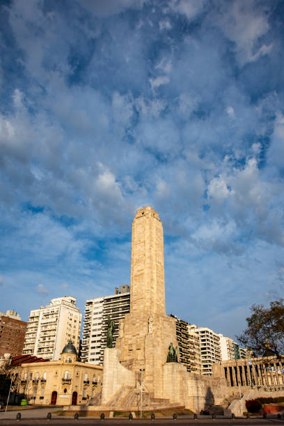 Argentina National Flag Monument vertical take, from far away.The photo have much sky on the image top. The Monument and the city skyline behind the monument, are located in the photo bottom.There is one person at far away in the monument, but is not reconogzible. The sky was slightly editated in its nivels and intensity of colours to make more intensity to the image. Photo taken the day August 15, 2022. In Rosario city, Santa Fe province, Argentina.