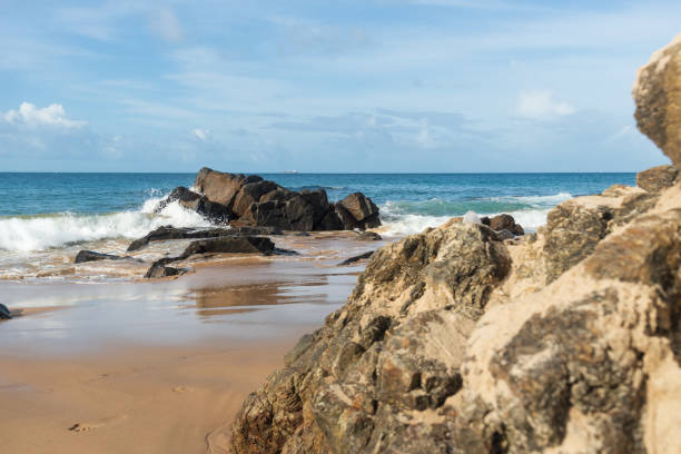 istock A wave breaks about a rock during a curtain on the sea. 1419159374