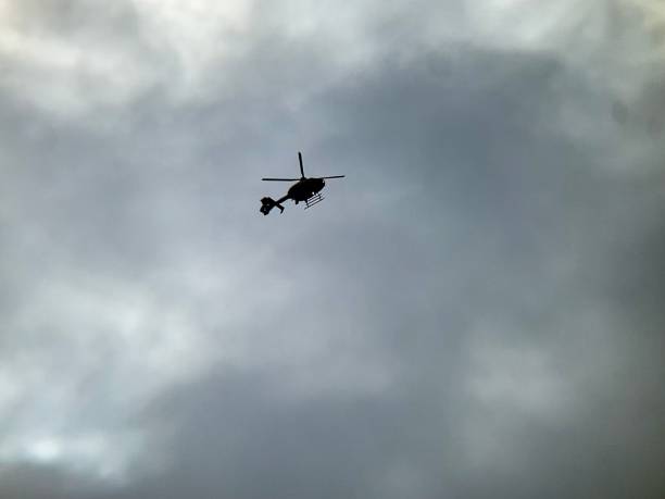 istock A silhouette of a helicopter against a grey cloudy sky 1419164996