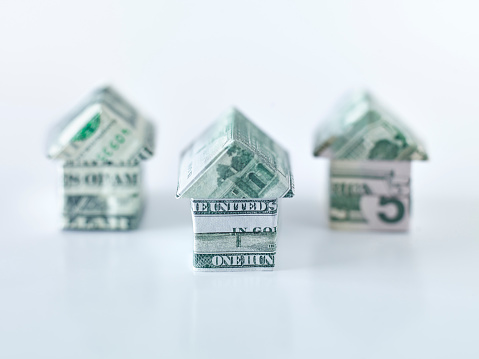 Origami dollar houses on white background