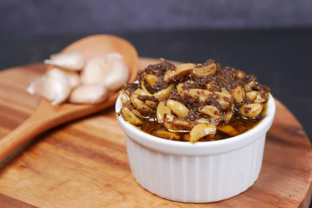 istock Homemade Garlic Pickle in a glass jar on table , 1419166170