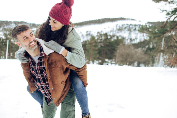 Portrait of a playful couple enjoying on the snow stock photo
