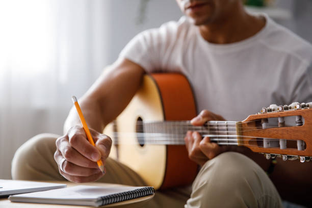 Man composing a song for acoustic guitar stock photo