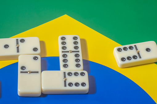 Domino game on top of a yellow and blue green flag,Brazilian colors,copy space.