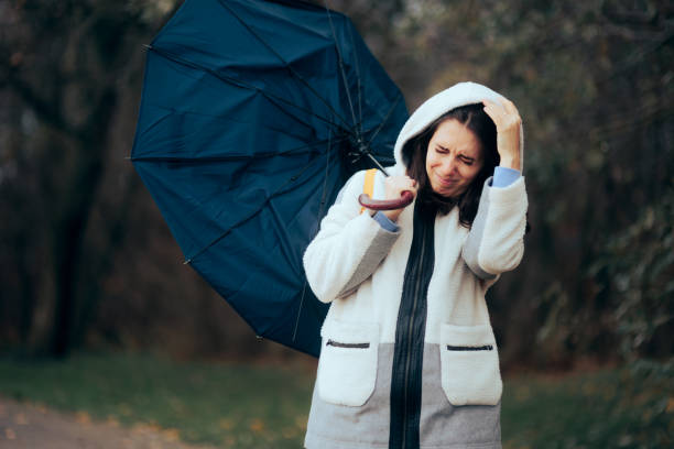 istock Woman Struggling During Raining Storm Holding an Umbrella 1419171147