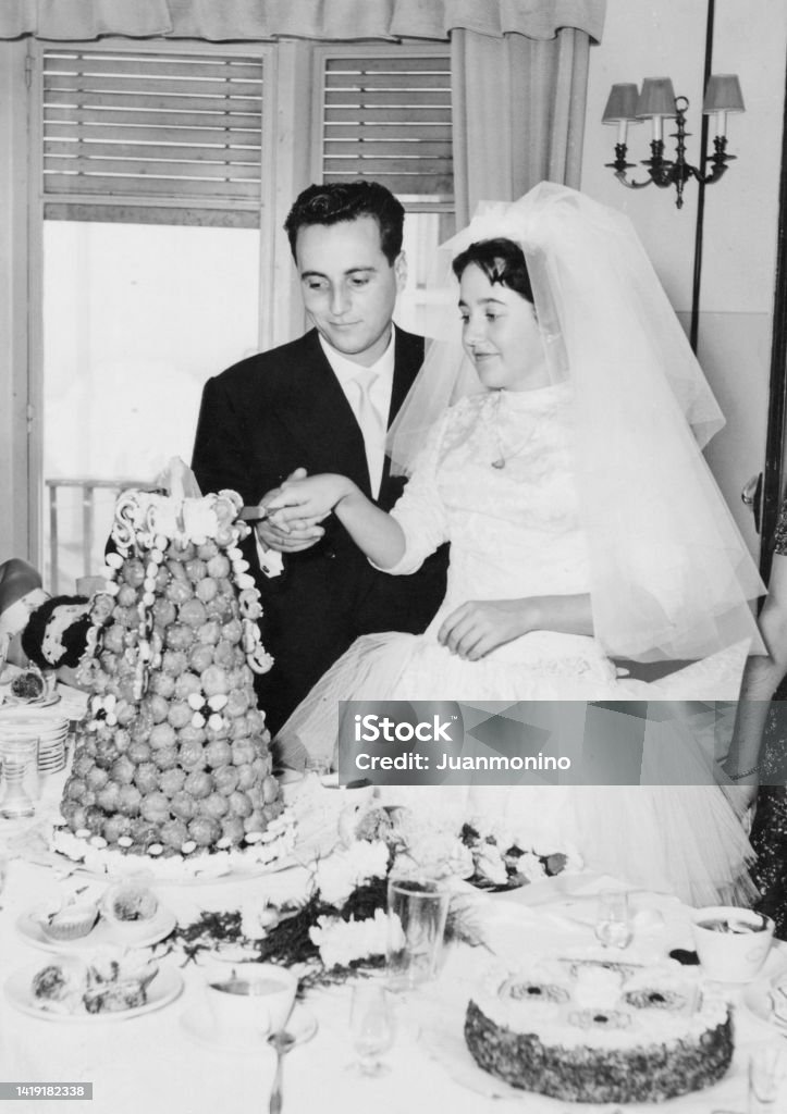 Vintage image from the 50s : Young couple posing cutting their wedding cake Retro Style Stock Photo
