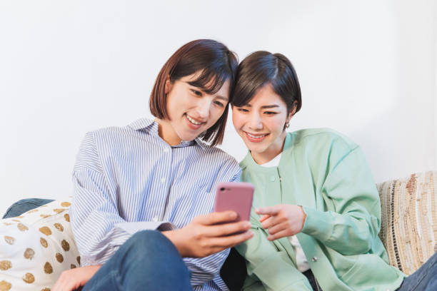 istock Two women looking at smartphones (women, couple, same surname, friend, sister) 1419184151