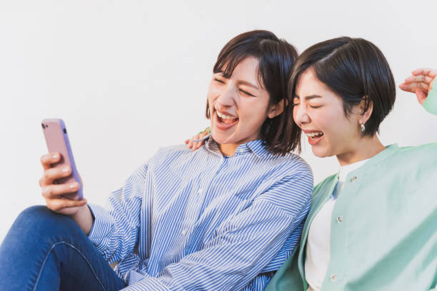 istock Two women looking at smartphones (women, couple, same surname, friend, sister) 1419184156