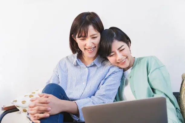 Two women looking at a computer (women, couple, same surname, friend, sister)